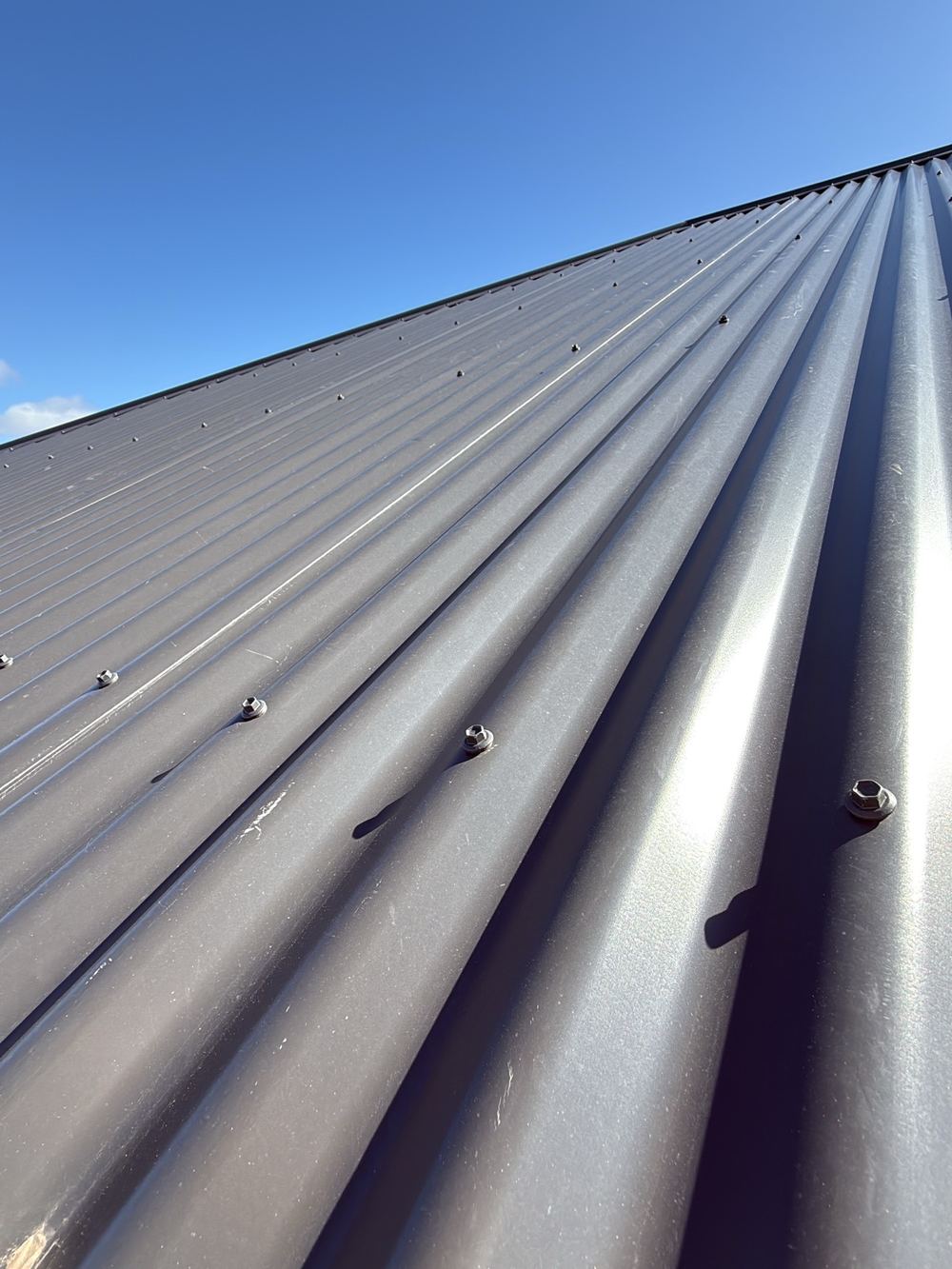 Metal roof sheets dented and scratched through the paint layer, found during a pre-handover inspection in Sunbury